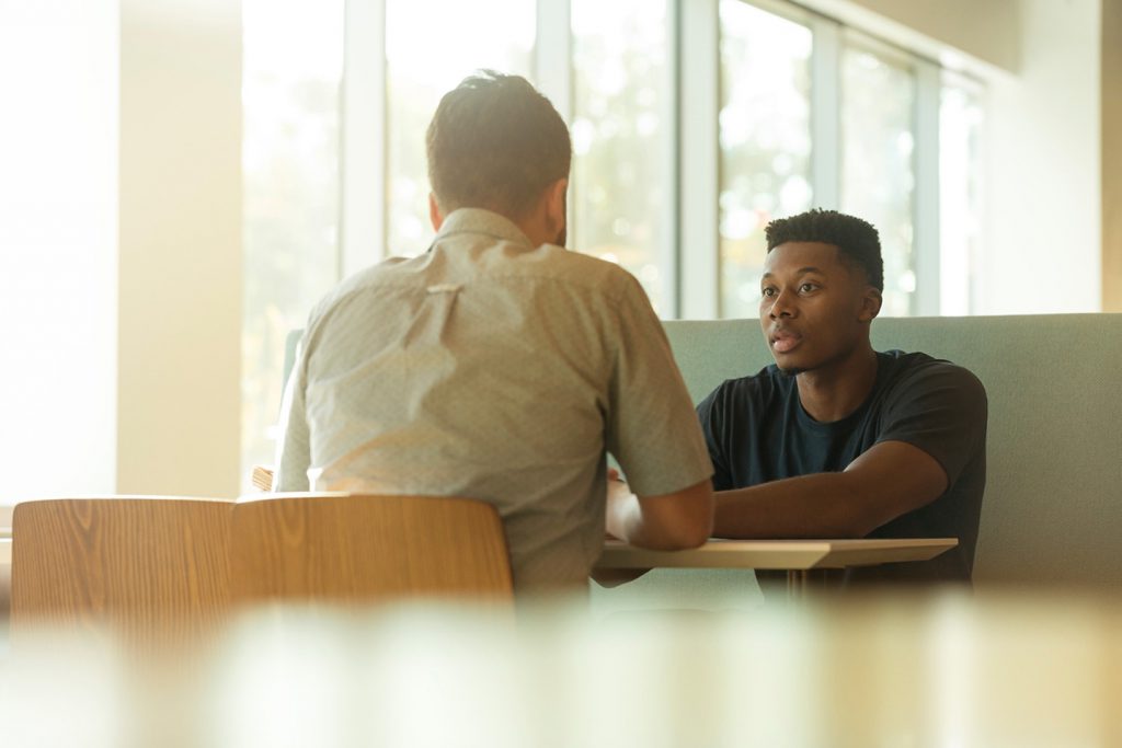 Two people talking at a table