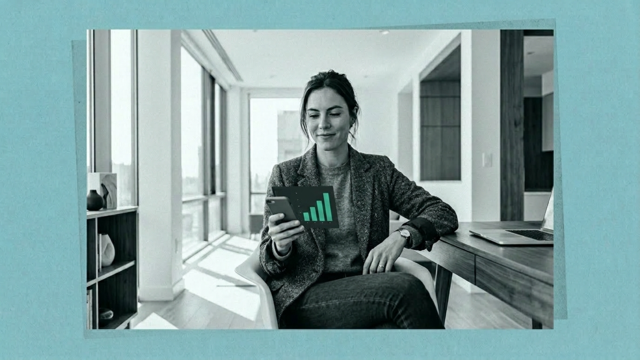 A young woman in a modern apartment reviews a financial app on her phone, a jade bar chart on screen the only color in the frame.