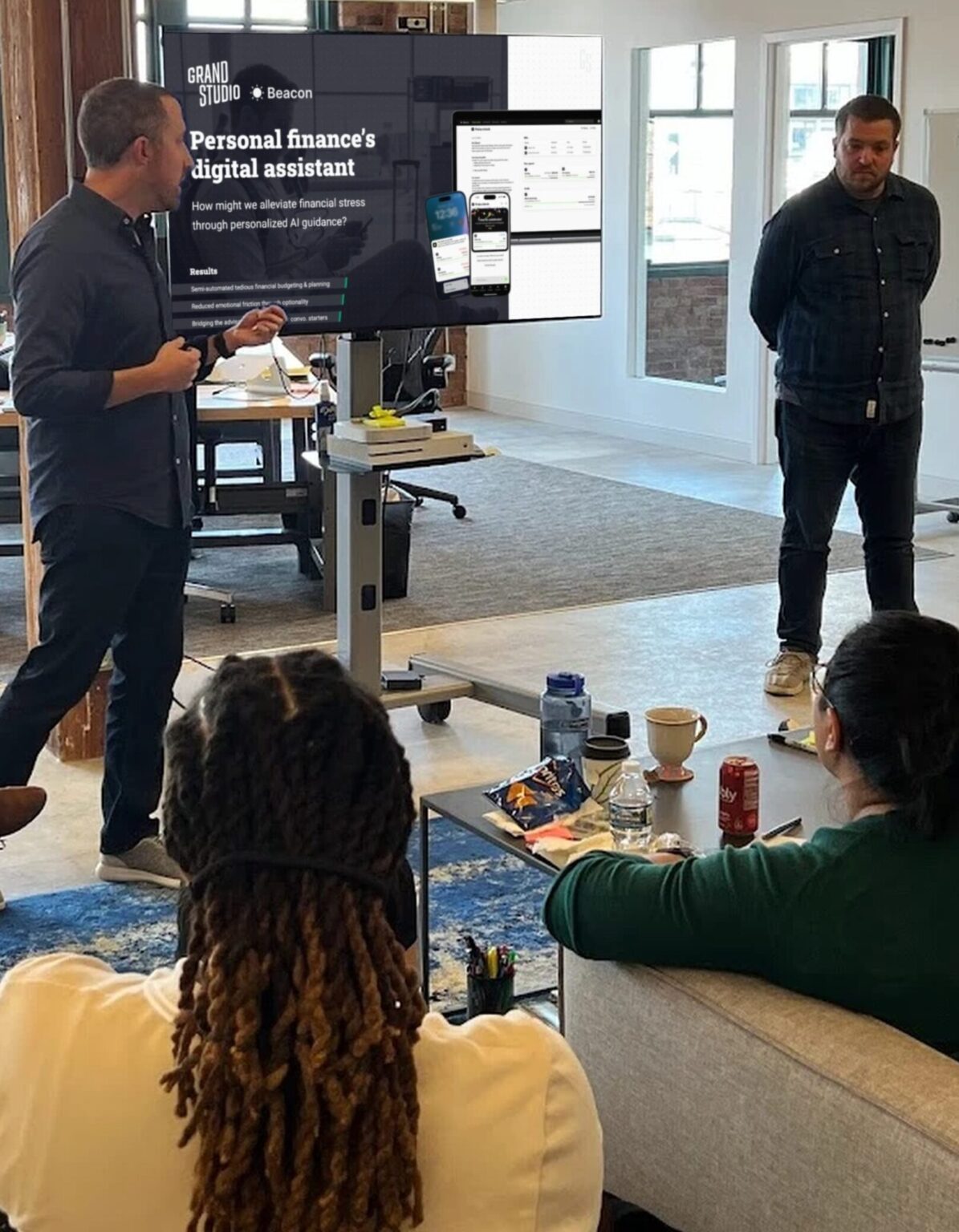 A Grand Studio team member presenting the Beacon project on a screen to colleagues in the studio